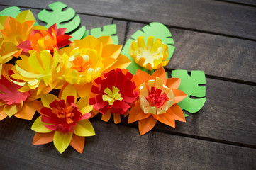 Flowers made of paper. Wooden background.