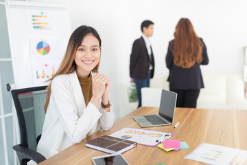 asian female officer relax in meeting room, she prepare information about organization performance, she feeling happy  and smile, happy workplace