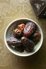 Date fruits in a bowl on ethnic metal plate. Ramadan kareem.