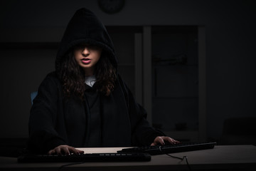 Female hacker hacking security firewall late in office