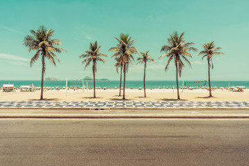 Sonniger Tag mit Palmen am Strand von Ipanema in Rio De Janeiro, Brasilien. Berühmter Mosaikweg vor dem Strand