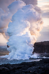 Fototapeta na wymiar Lava pouring into the sea causing steam clouds