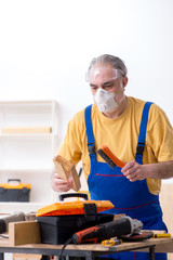 Old male carpenter working in workshop