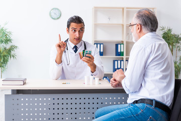 Old man visiting young male doctor