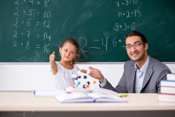 Teacher with young girl in the classroom