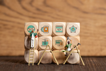 little painter figure and wooden blocks with error icons on wooden background