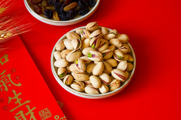 pistachio in a plate isolate on red background