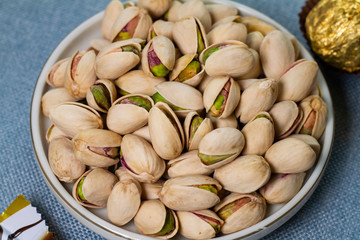 pistachio in a plate isolate on blue background	