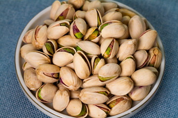 pistachio in a plate isolate on blue background