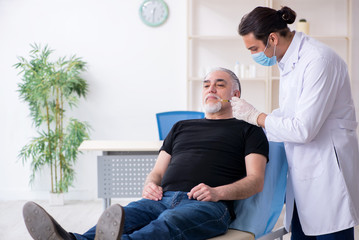 Old man visiting young doctor for plastic surgery