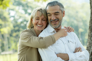 Happy senior couple hugging in park  in love and romantic