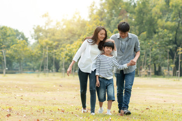 happy family, mom, dad and son walking in park