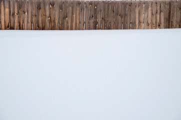 Wooden fence and white snow in Siberia