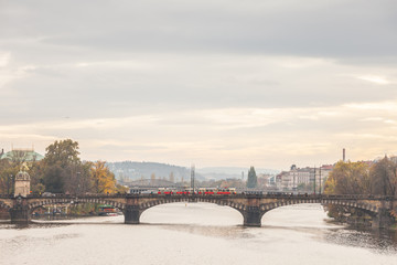 Panorama of Prague, Czech Republic, seen from the Vltava river, also called Moldau, with a focus on Most Legii, or Legion Most, one of the landmarks of the city, during a cloudy sunset in autumn