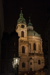 Fototapeta na wymiar Kostel Svety Mikulase Church (Saint Nicholas) illuminated at night in prague, in the Mala Strana district of Medieval Prague, Czech Republic. It is a Catholic Baroque church