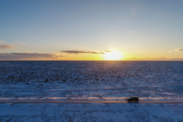 Car driving along Icelandic snowy landscape