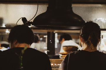 Rear view of couple dating at yakiniku  restaurant