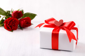 White gift box red ribbon and roses