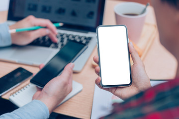 Mockup image blank white screen cell phone.woman hand holding texting using mobile on desk at office.background empty space for advertise text.people contact marketing business,technology 