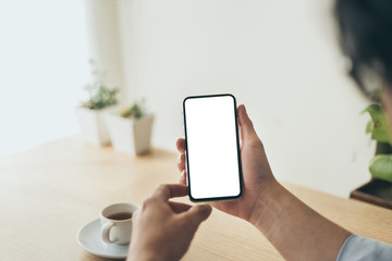 Mockup image blank white screen cell phone.man hand holding texting using mobile on desk at office.background empty space for advertise text.people contact marketing business,technology 