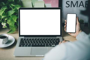 mockup image blank screen computer,cell phone with white background for advertising text,hand man using laptop texting mobile contact business search information on desk in cafe.marketing,design