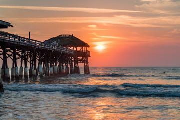 Sun rising over a pier