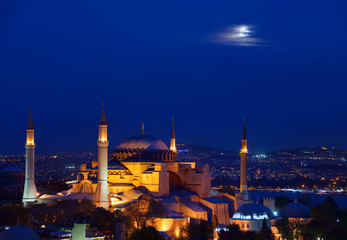 Fototapeta na wymiar Night lights on Hagia Sophia under a full moon at twilight in Istanbul Turkey