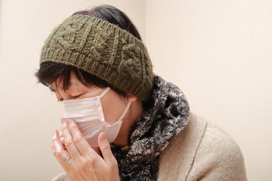 Middle Aged Woman Wearing A Mask And Catching A Cold