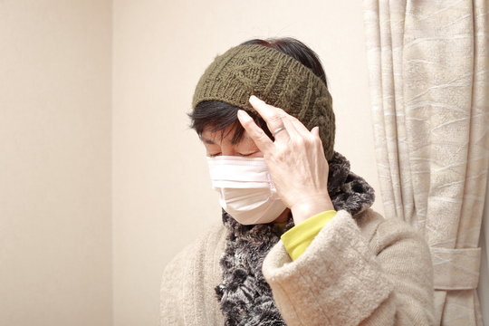 Middle Aged Woman Wearing A Mask And Catching A Cold