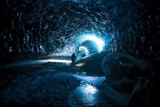 Female Explorer Standing Inside Ice Cave Tunnel, Iceland