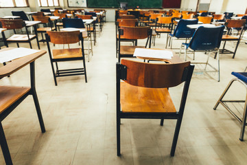 selective soft and blur focus.old wooden row lecture chairs in dirty classroom in poor school.study room without student.concept for education in third world ,donate and charity,background text.