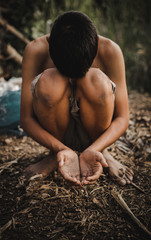 hands poor child or beggar begging you for help sitting at dirty slum. concept for poverty or...