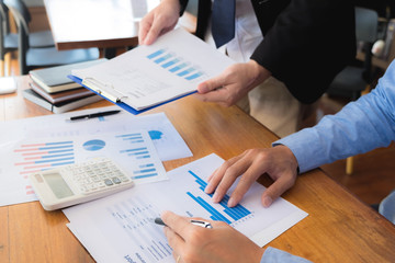 Sitting and working, consulting and suggesting work, checking work reports with a calculator in a business office.