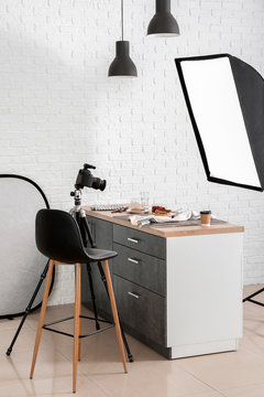 Interior of modern photo studio with professional equipment and food on table