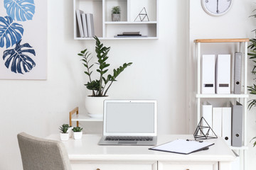 Fototapeta na wymiar Stylish comfortable workplace with laptop in modern room