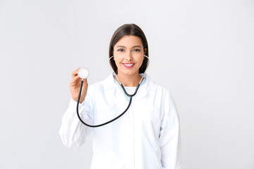 Female cardiologist on light background