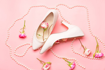 Beautiful rose flowers with beads and high-heels on color background. International Women's Day celebration