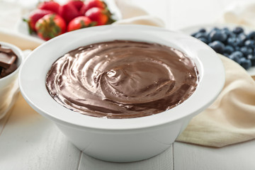 Bowl with tasty chocolate fondue on table