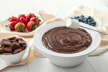 Bowl with tasty chocolate fondue and marshmallow on table