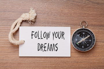 Follow your dreams - Motivation handwriting on label with compass