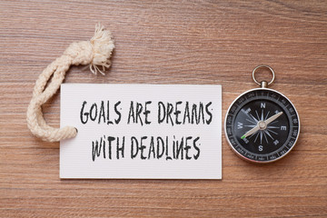 Goals are dream with deadlines - Motivation handwriting on label with compass