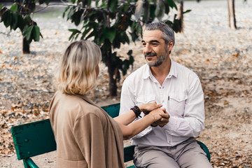 Obraz premium Lovely senior elderly smiling couple man and woman holding hand as promising of forever love or take care in romantic moment. Warm heart marriage and lover bonding and relationship Love photo concept.