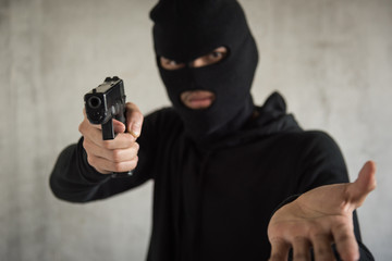 Robber with gun aiming into people