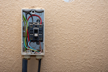 Fototapeta na wymiar Residential exterior electrical box in need of repair with wires and switches exposed. DIY, repair, mainentance concepts. Copy Space.