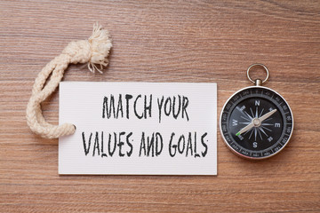 Match your value and goals -  inspirational advice handwriting on label with compass