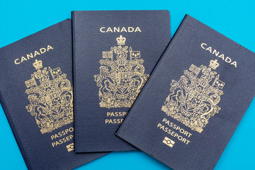 Canada passport on bright blue flat lay background. Travel and vacation concept.