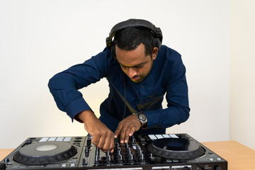 Male DJ playing music on white background