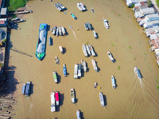 Fototapeta na wymiar Aerial view of Cai Rang floating market at sunrise, boats selling wholesale fruits and goods on Can Tho River, Mekong Delta region, South Vietnam, tourism destination.