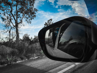 Fototapeta na wymiar Black Mirror car while driving on a highway in Thailand