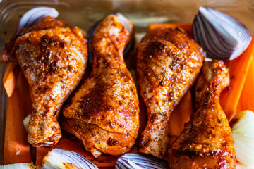 Marinated raw chicken drumsticks ready to roast
